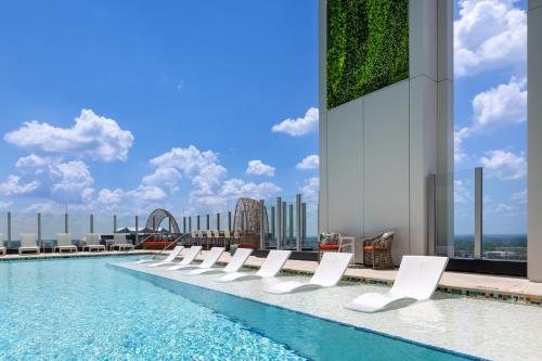 a swimming pool with white chairs and a roller coaster at Atlanta Resort 1BR Apartment in Atlanta