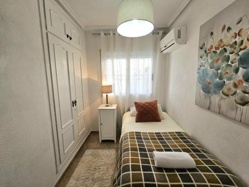 a small bedroom with a bed and a window at Chalet con Piscina Privada, Aguas Nuevas, Torrevieja in Torrevieja