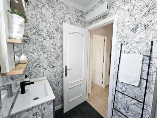 a bathroom with a white sink and a wall at Chalet con Piscina Privada, Aguas Nuevas, Torrevieja in Torrevieja