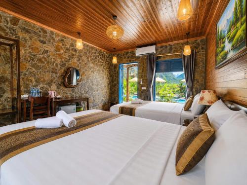 a hotel room with two beds and a table at Trang An River Sunshine in Ninh Binh