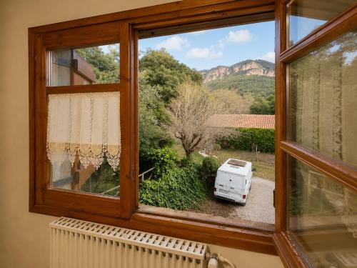 a window with a view of a van in a yard at Winahost Espunyola Berga in L'Espunyola