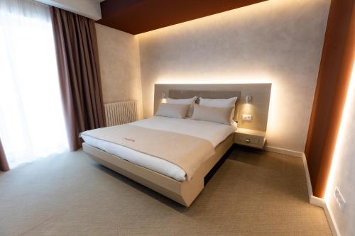 ein Schlafzimmer mit einem großen Bett in einem Hotelzimmer in der Unterkunft Civico14 in Târgovişte