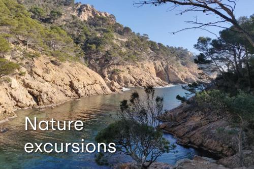 a river with the words nature excursions on the side of a mountain at Hotel - Bungalows Don Juan Tossa in Tossa de Mar