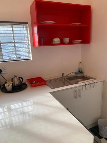 a kitchen with a sink and a red cabinet at Savoy Hotel Beaufort-West in Beaufort West