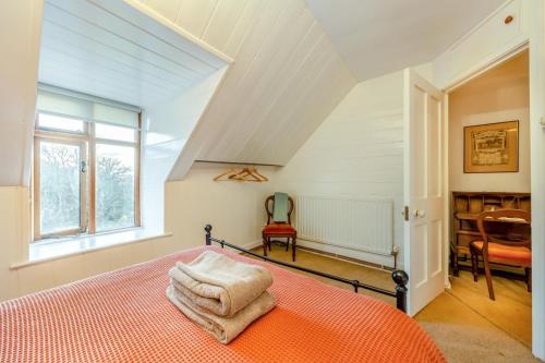 a bedroom with a bed with orange sheets and a window at Y Cwtch - Panoramic mountain views within Snowdonia's National Park - 4x4 only in Dolgellau