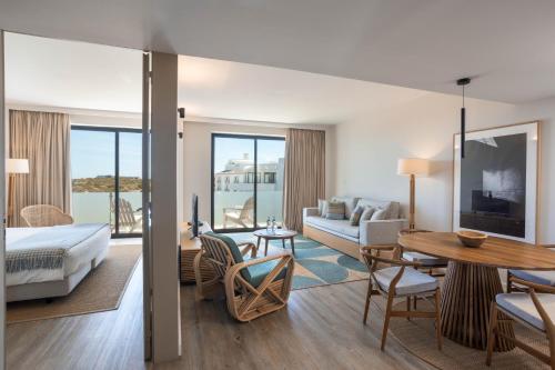 a hotel room with a bed and a living room at Memmo Baleeira - Design Hotels in Sagres