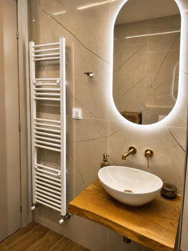 a bathroom with a white sink and a mirror at Sea & Sun Luxury Apartment in Alexandroupoli