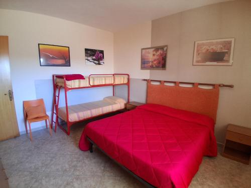a bedroom with two bunk beds and a red bedspread at Casa vacanze ESTER in San Foca