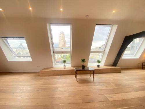a large room with large windows and a table at 12-Guest Apartment on the Main Square in Antwerp
