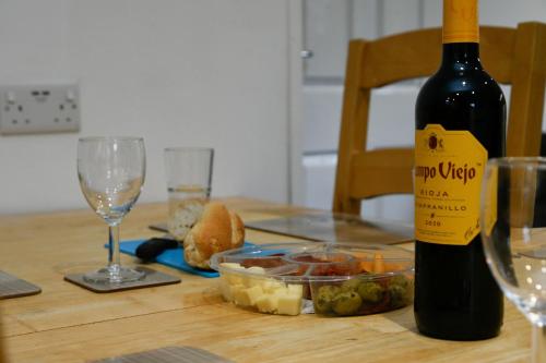 a bottle of wine and a bowl of food on a table at Muck in Oban