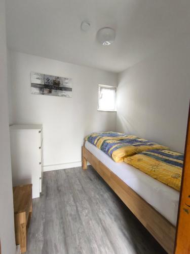 a bedroom with a bed and a window at FeWo Antweiler Oberdorf in Mechernich