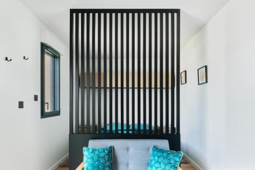 a room with a blue couch and a black and white wall at Le Cocon de Brocéliande - Studio cosy et indépendant in Saint-Thurial