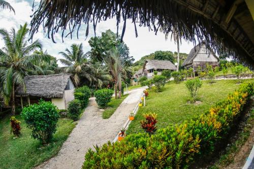 a path through a village with houses and trees at Antafondro Lodge in Sainte Marie
