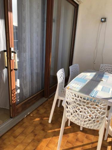 a white table and chairs in a room at résidence Fogata in LʼÎle-Rousse