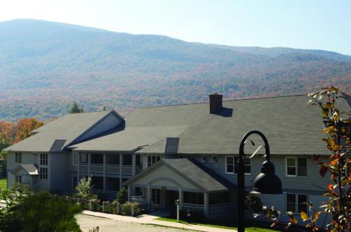 a house with a mountain in the background at Smugglers' Notch Resort 2BR Apartment in Cambridge