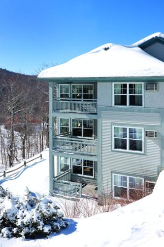 a large house with snow on the ground at Smugglers' Notch Resort 2BR Apartment in Cambridge