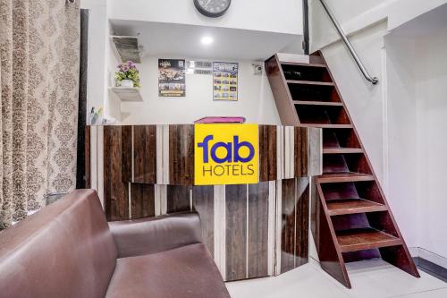 a living room with a couch and a staircase at FabHotel Blue Light in Mumbai