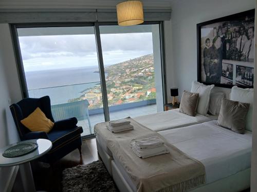 a bedroom with a bed and a large window at Villa Calçada in Santa Cruz