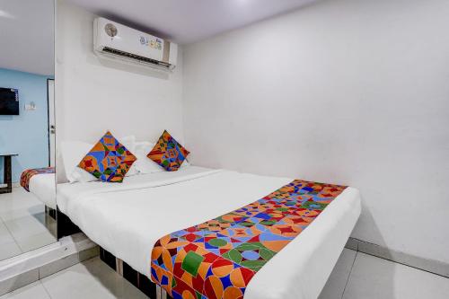 a bedroom with a bed with a colorful comforter at FabHotel Blue Light in Mumbai