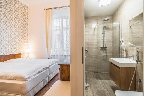 a bathroom with a bed and a shower and a sink at CenterCity Apartments in Prešov