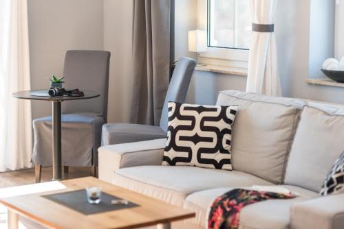 a living room with a couch and a table at Neue Galerie App 3 in Ahrenshoop