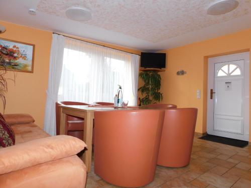 a kitchen with an orange island in a living room at Sterntaucher Bungalow App 5 in Ahrenshoop