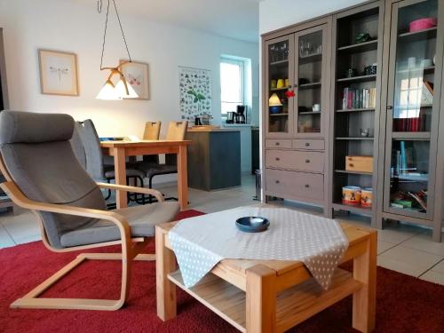 a living room with a chair and a table at Malvenhus in Ahrenshoop