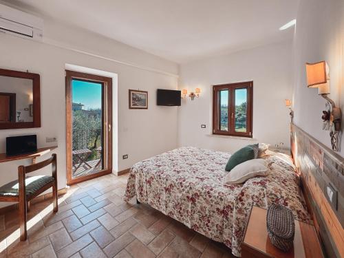 a bedroom with a bed and a desk and a window at La Casa di Joy in Acquasparta