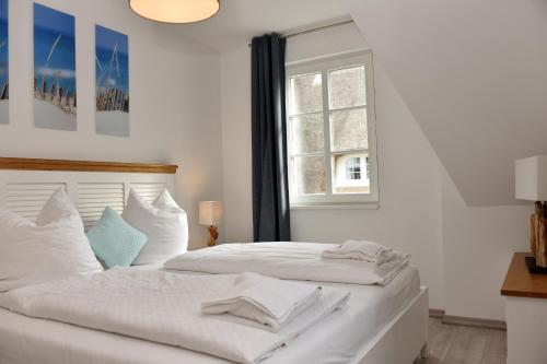 a white bed in a bedroom with a window at Ostseefeeling in Wustrow