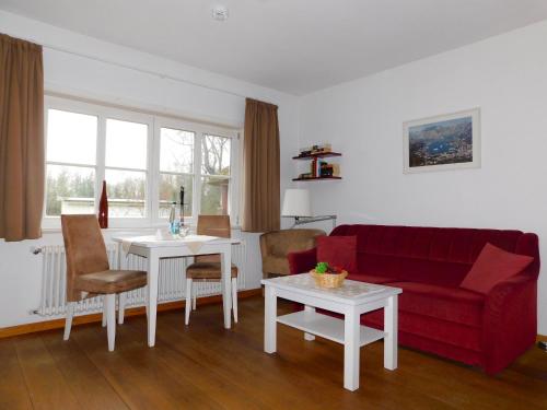 a living room with a red couch and a table at Puppenhaus in Ahrenshoop