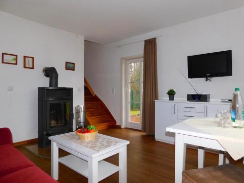 a living room with a fireplace and a table at Puppenhaus in Ahrenshoop