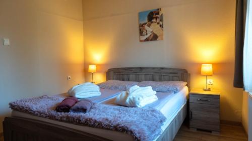 a bedroom with a bed with towels and two lamps at Tolcsvai Fogadó in Tolcsva