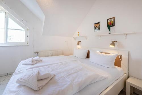 a white bed with white sheets and towels on it at Hummer in Althagen