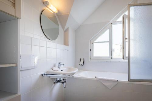 a white bathroom with a sink and a mirror at Hummer in Althagen
