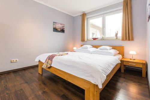 a bedroom with a bed with white sheets and a window at Abendrot in Ahrenshoop