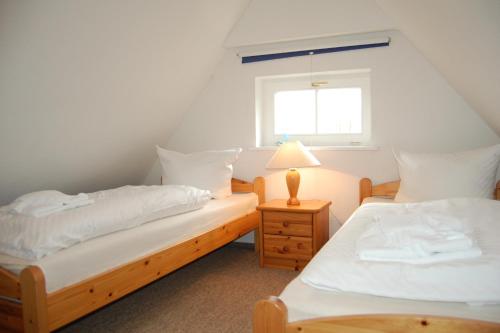 two twin beds in a room with a window at Altes Backhaus 2 in Althagen