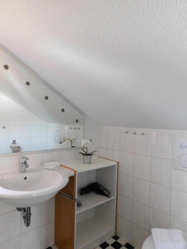 a white bathroom with a sink and a toilet at Altes Backhaus 2 in Althagen