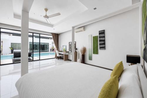 a bedroom with a bed and a living room at Exclusive Tropical Living! Elegant 4BR Villa Destiny with Salt Pool in Rawai Beach