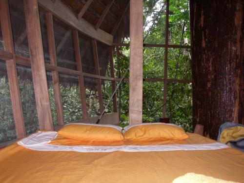 a bed in a tree house with two pillows at Reserva Natural Tanimboca in Leticia