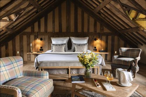 a bedroom with a bed and two chairs and a table at La Ferme Saint Simeon Hotel & Spa - Relais & Chateaux in Honfleur