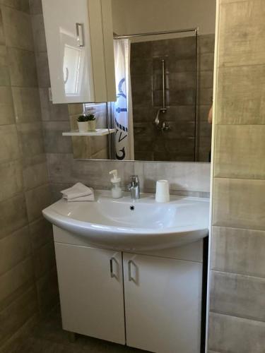 a bathroom with a white sink and a mirror at TAL in Tisno
