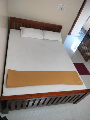 a bed with a wooden bed frame in a room at gururesidency in Tiruvannāmalai