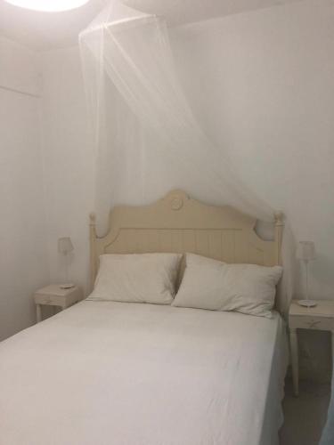 a bedroom with a white bed with two night stands at Chery Private Suite in Marsa Alam City