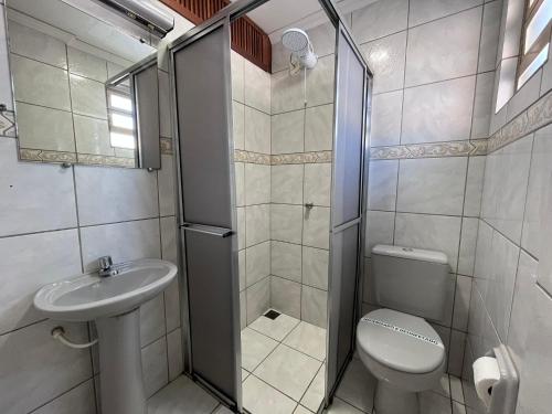 a bathroom with a shower and a toilet and a sink at Rosa's Hotel in Toledo