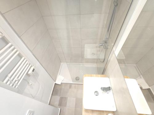 a white bathroom with a sink and a shower at Casa Toronzue in Frajén