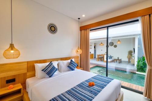 a bedroom with a bed and a swimming pool at Tapan Harmony Villa Ubud in Ubud