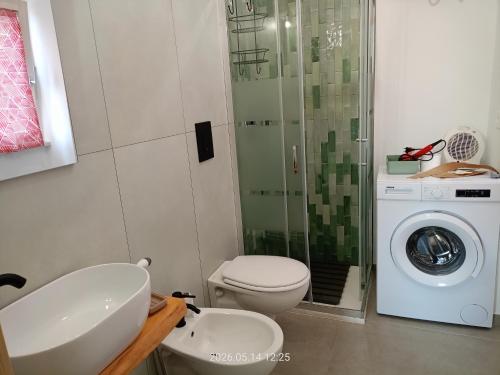 a bathroom with a toilet and a washing machine at casa di Chiarina con parcheggio gratuito nel cortile privato in Binetto