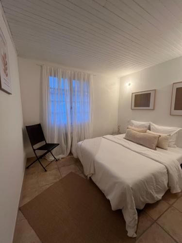a white bedroom with a large bed and a window at Finca Avrafina in Tarascon
