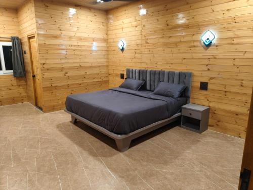 a bedroom with a bed in a wooden wall at Mount Bliss Resort in Mhasla