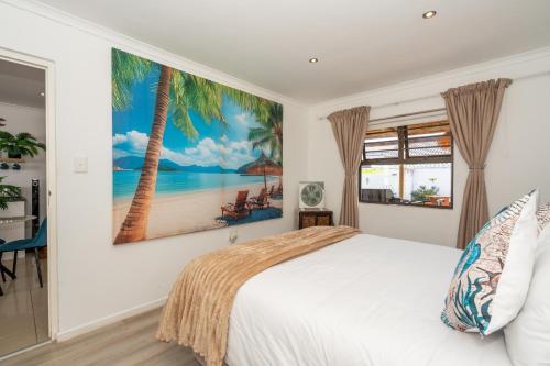 a bedroom with a bed and a painting of a beach at Where Time Stops in Langebaan